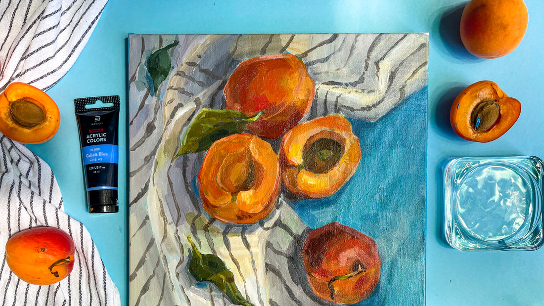 There's an image of acrylic painting with still life peaches and striped fabric. Nearby there're peaches and acrylic paint tube on the blue background.